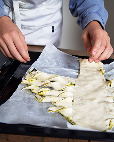 Recette de Noël : le sapin au pesto de Circé. Découpe dans la pâte de la forme d’un sapin avec des branches.