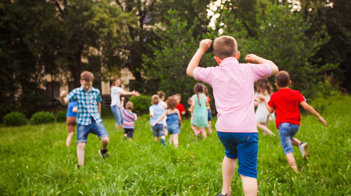 Des enfants courent dans un pré.